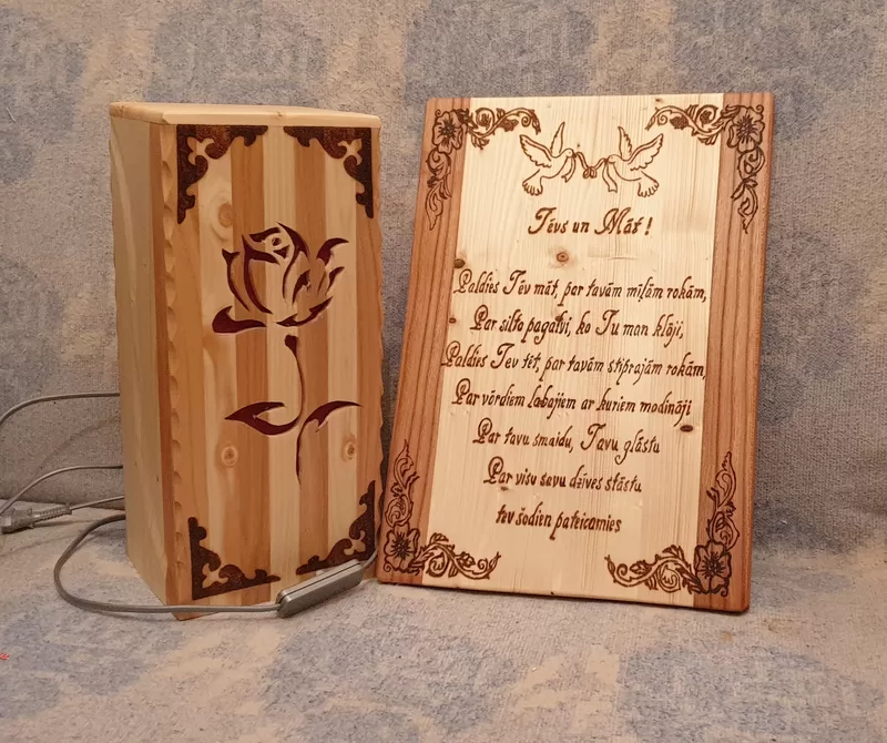 Izgatavojam koka galda lampas un personalizētus koka piemiņas dēlīšus ar gravējumu, tekstu un individuālu dizainu. Šāds dāvanu komplekts ir īpaši piemērots kā pateicības dāvana vecākiem, krustvecākiem, jaunajam pārim vai citiem tuviem cilvēkiem kāzās, jubilejās un citos nozīmīgos dzīves notikumos. Dabīgais koks, rūpīgi izstrādātas detaļas un personalizēts vēstījums padara šo komplektu par sirsnīgu un paliekošu piemiņu.  Koka lampa ar gravējumu piešķir telpai siltu un mājīgu noskaņu, savukārt koka pateicības dēlītis ar individuālu tekstu un ornamentiem kļūst par īpašu atgādinājumu par nozīmīgu dzīves brīdi. Katrs izstrādājums tiek veidots ar rūpību, pielāgojot tekstu, vārdus, datumu vai citus dizaina elementus atbilstoši klienta vēlmēm.  Šis personalizētais koka dāvanu komplekts ir lieliska izvēle, ja meklējat oriģinālu pateicības dāvanu no koka, gravētu koka lampu, koka piemiņas dēlīti ar tekstu vai elegantu un personīgu dāvanu kāzām. Piedāvājam individuālu pieeju un kvalitatīvu izpildījumu, lai katrs komplekts būtu unikāls un emocionāli nozīmīgs.
